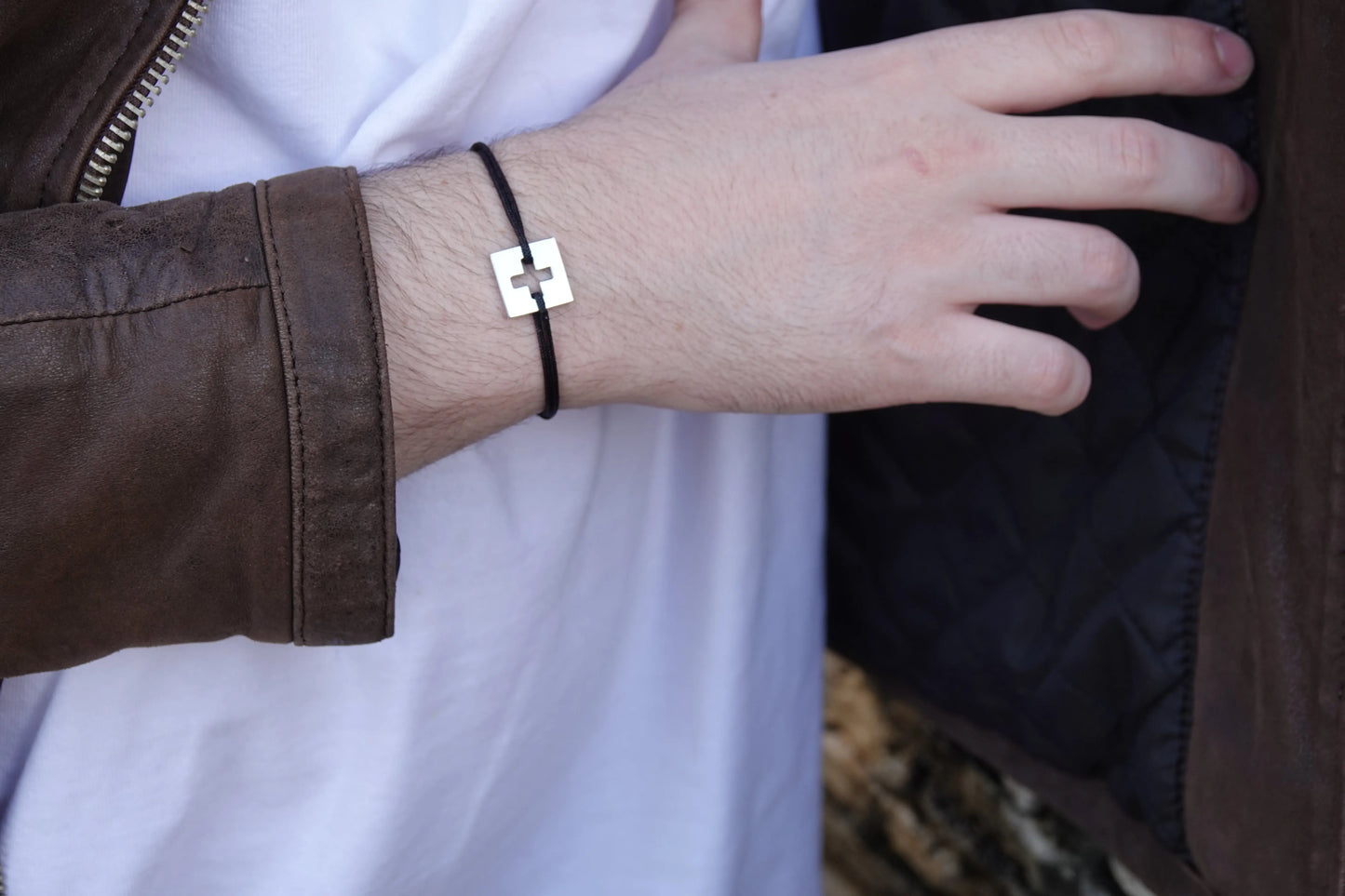 Bracelet SwissFlag en argent rhodié et cordon noir sur poignet d'homme