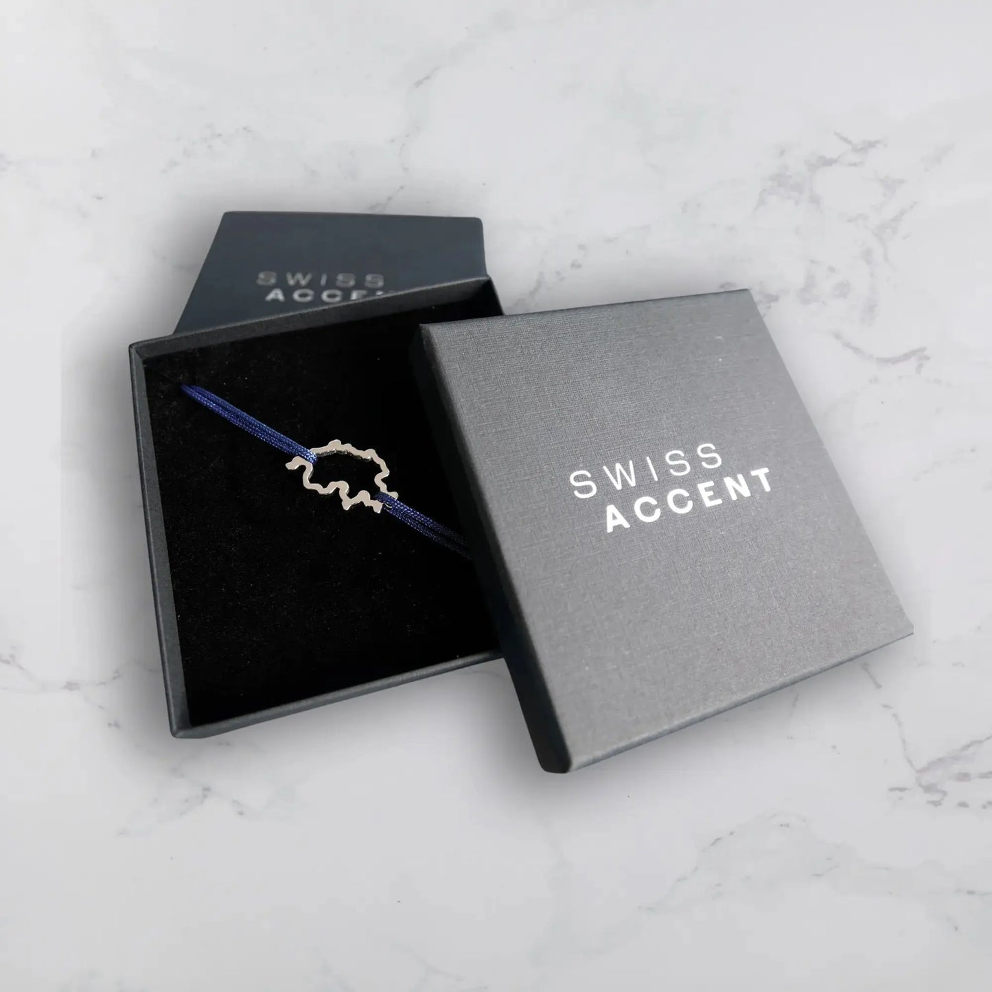 Bracelet SwissMap en argent rhodié et cordon bleu dans la boite noire de Swiss Accent