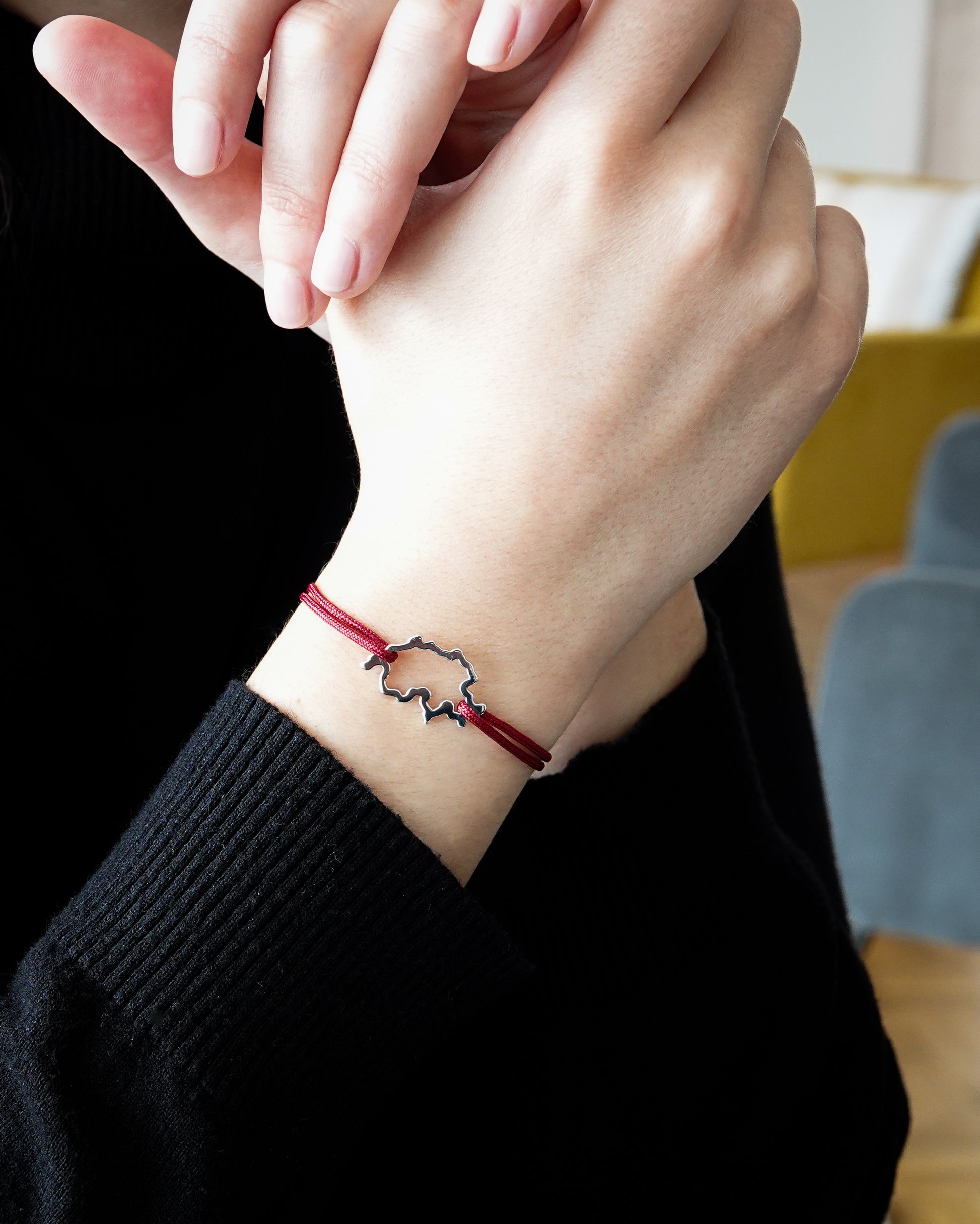 Bracelet SwissMap en argent rhodié et cordon rouge sur poignet de femme